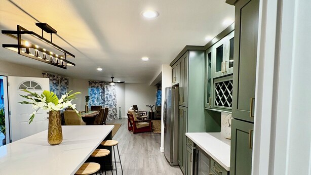 A modern kitchen with a long island, bar stools, and a dining table. - MSG host to confirm availability.• Spacious 3Bed 2BA •Sleeps 10 (Laie)
