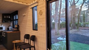 A cozy interior with a wooden interior, a kitchen area, and a view of the outdoors. - The TINY HOUSE at Le Haras. (Avrillé)