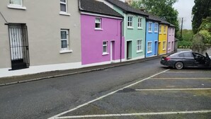 Un conjunto de casas coloridas con un coche estacionado al frente.
