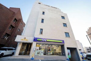 A multi-story building with a CU store on the ground floor, a visible entrance, and a parking area in front. - hotel onggi (Gyeongju)