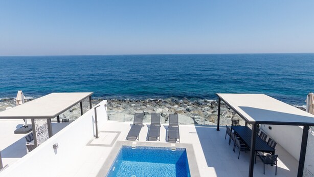 A rooftop pool with a view of the sea, lounge chairs, and a table. - Arabian Gulf-Facing 4BR Villa with Two Assistant Room, Heated Pool and Barbecue Space, Al Dana Island, Fujairah (Fujairah)