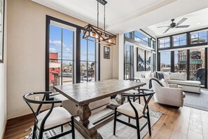 Enjoy meals with family and friends at the large dining table surrounded by four chairs, with a city view from the large window.