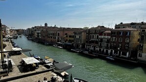 A canal with buildings on one side and a dock with boats on the other. - Luxurious 300 sqm Apartment with Canal View in Cannaregio (Venezia)