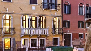 A narrow canal with a red boat docked at the edge. - Luxurious 300 sqm Apartment with Canal View in Cannaregio (Venezia)