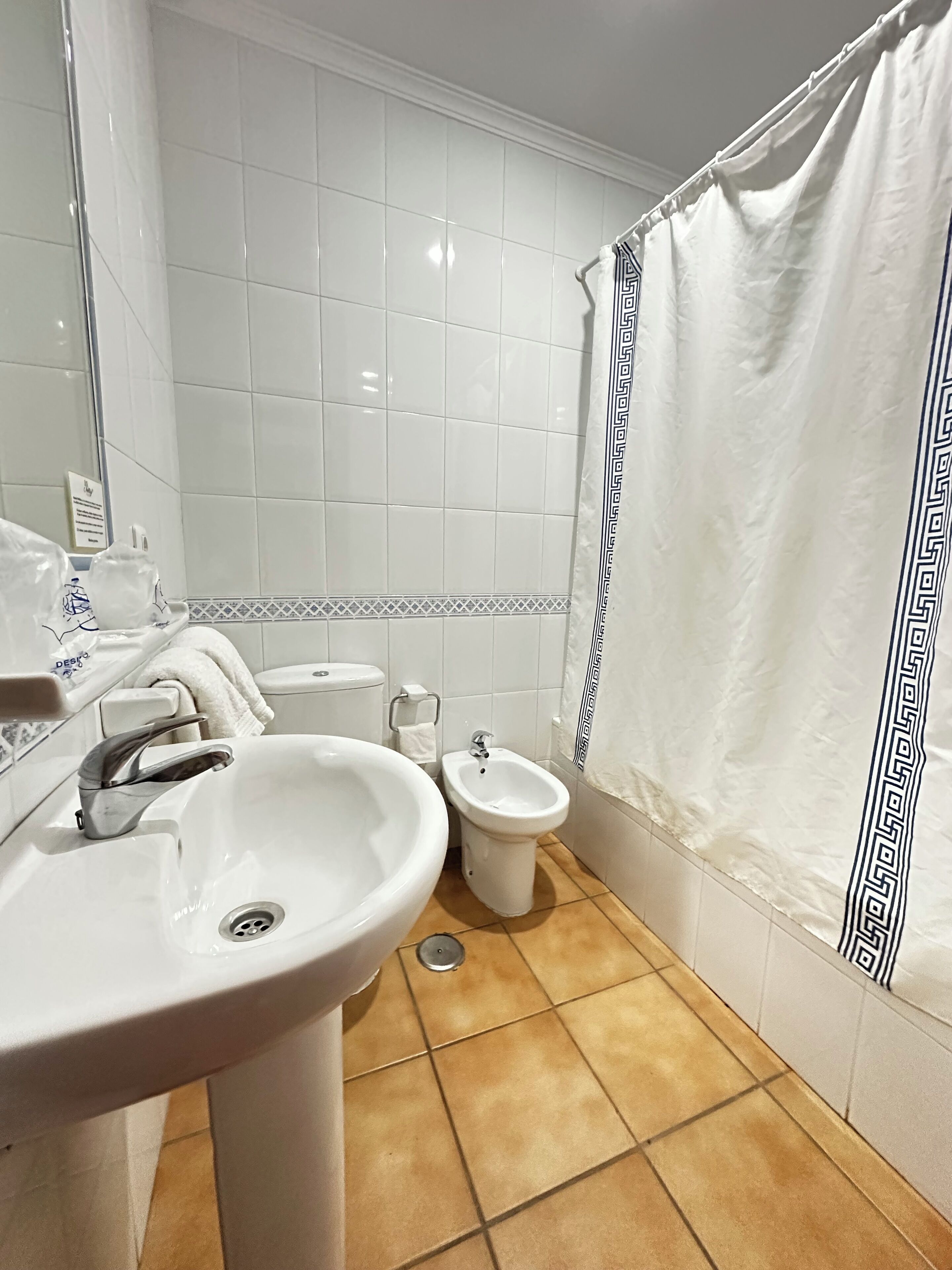 A bathroom with a sink, bidet, and toilet.