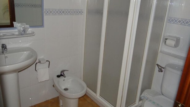 Un bagno con lavandino, bidet, WC e cabina doccia.