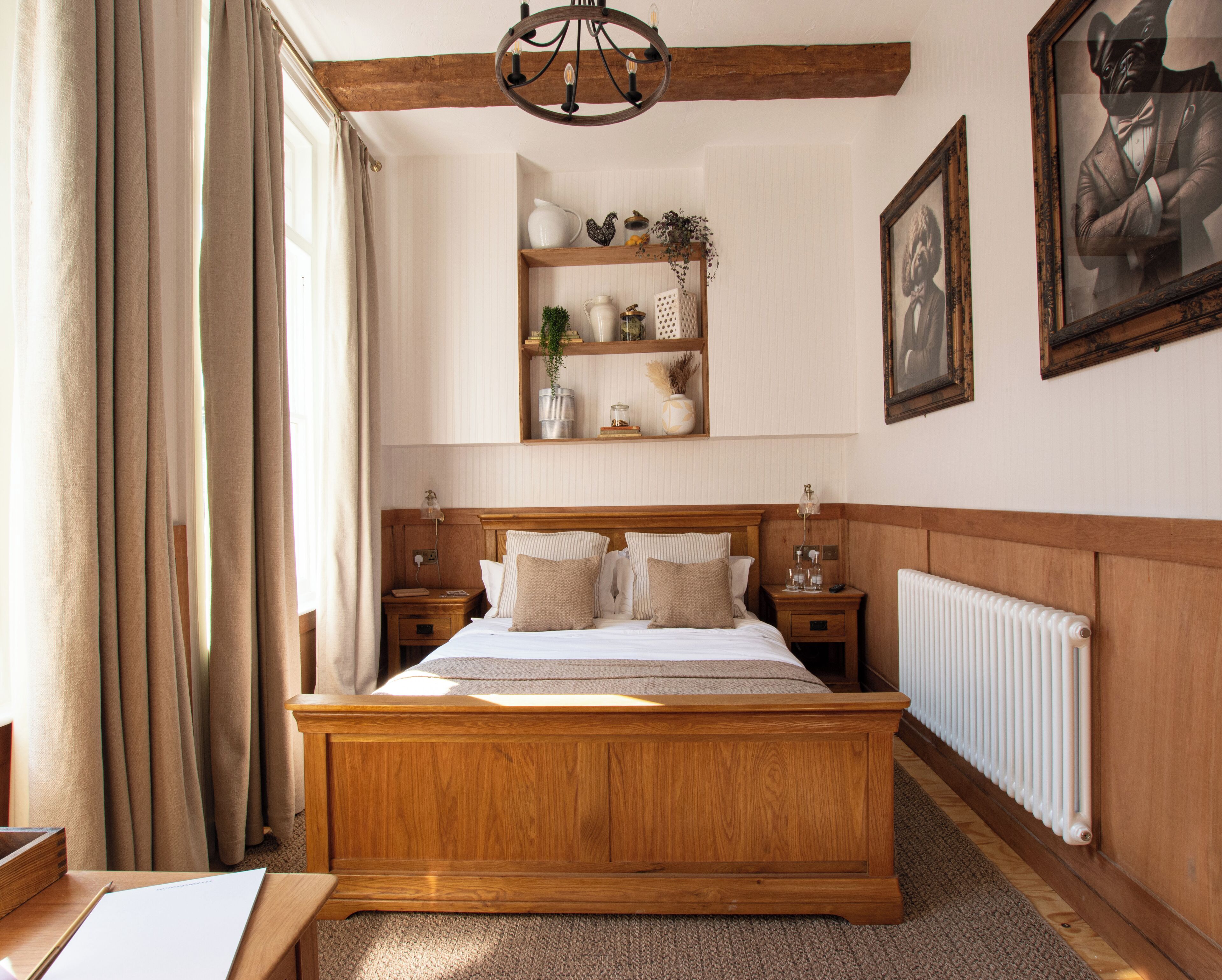 A bedroom with a wooden bed, bedside tables, a radiator, and a shelf with decorative items.
