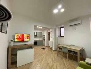 A compact living space with a kitchenette, a dining area, and a TV mounted on the wall. - Largo Zeza Fifteen Holiday Home (Bojano)