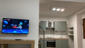 Une cuisine moderne dotée d’un four encastré, d’une cuisinière à gaz et de meubles de couleur claire.