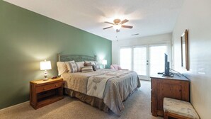 A bedroom with a bed, nightstand, chair, and a ceiling fan. - One Bedroom Marina View Condo (Grand Rivers)