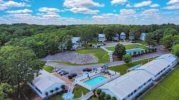 A large resort with multiple buildings, a swimming pool, and a well-maintained lawn.