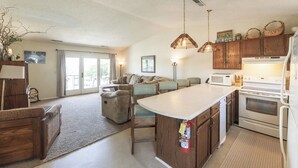 Une cuisine moderne avec des meubles en bois, un îlot central et un coin repas comprenant un canapé et des chaises.