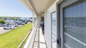 Un balcon donnant sur un parking et sur un immeuble en arrière-plan.