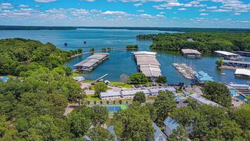 A marina with docked boats, a tennis court, and surrounding greenery.
