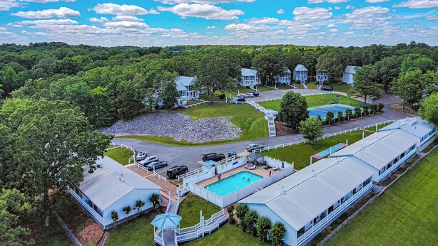 A large resort with multiple buildings, a swimming pool, and a well-maintained lawn. - Two Bedroom Harbor View Condo (Grand Rivers)