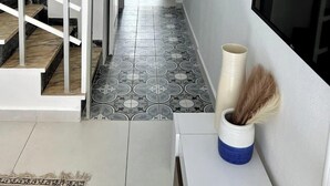 Käytävällä on portaikko, joka johtaa parvekkeelle, seinällä on kehystetty taulu ja seinään on asennettu televisio.