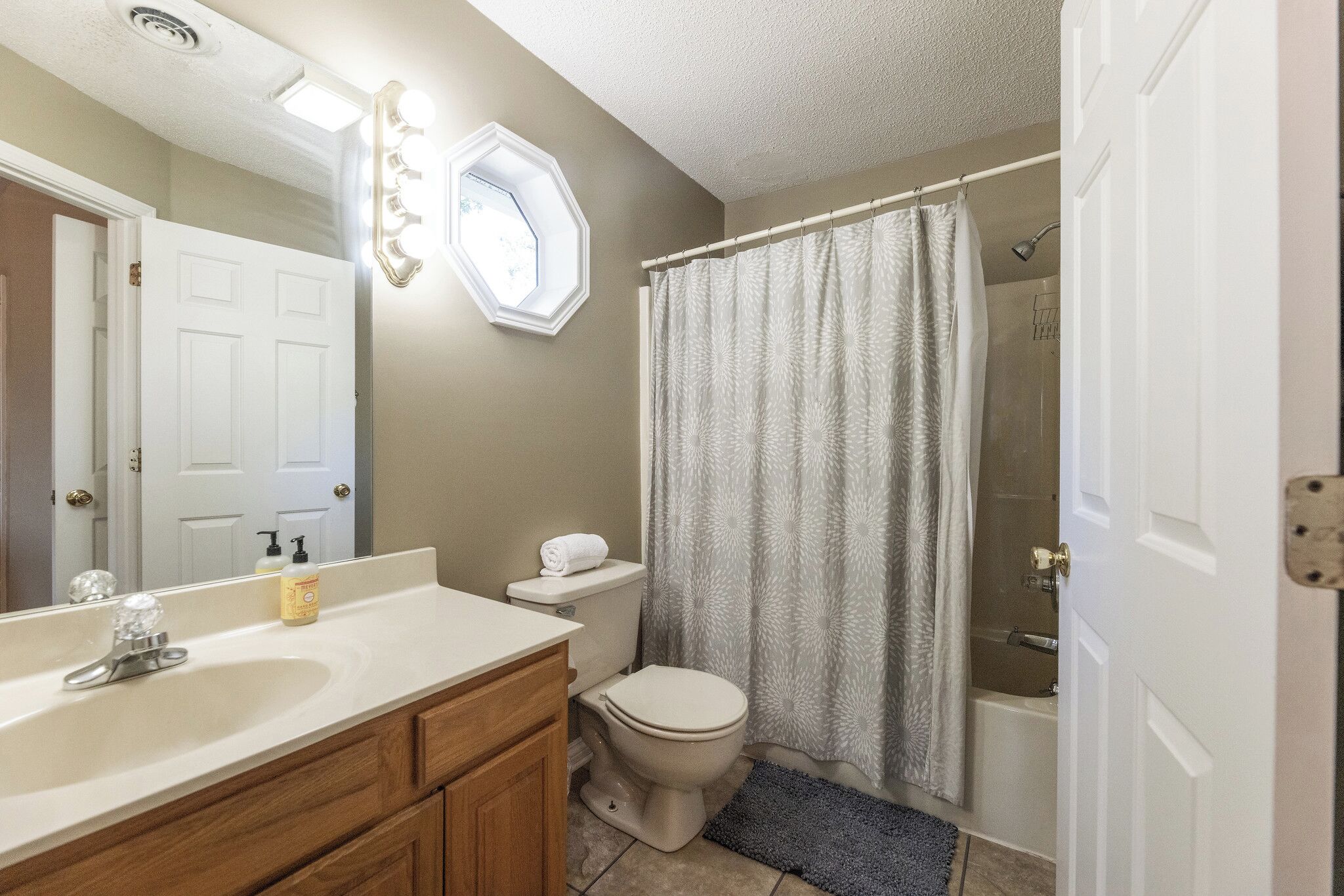 Une salle de bain avec un lavabo, des toilettes et un rideau de douche.