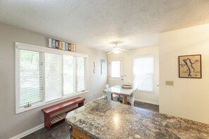 A kitchen with a granite countertop, a dining table, and a bench. - Three Bedroom Hurst Haven Condo (Grand Rivers)