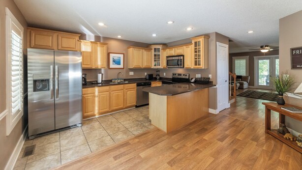 A modern kitchen with wooden cabinets, stainless steel appliances, and a central island.