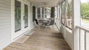 A covered porch with a table and chairs, a ceiling fan, and a view of the outdoors. - Three Bedroom Hurst Haven Condo (Grand Rivers)