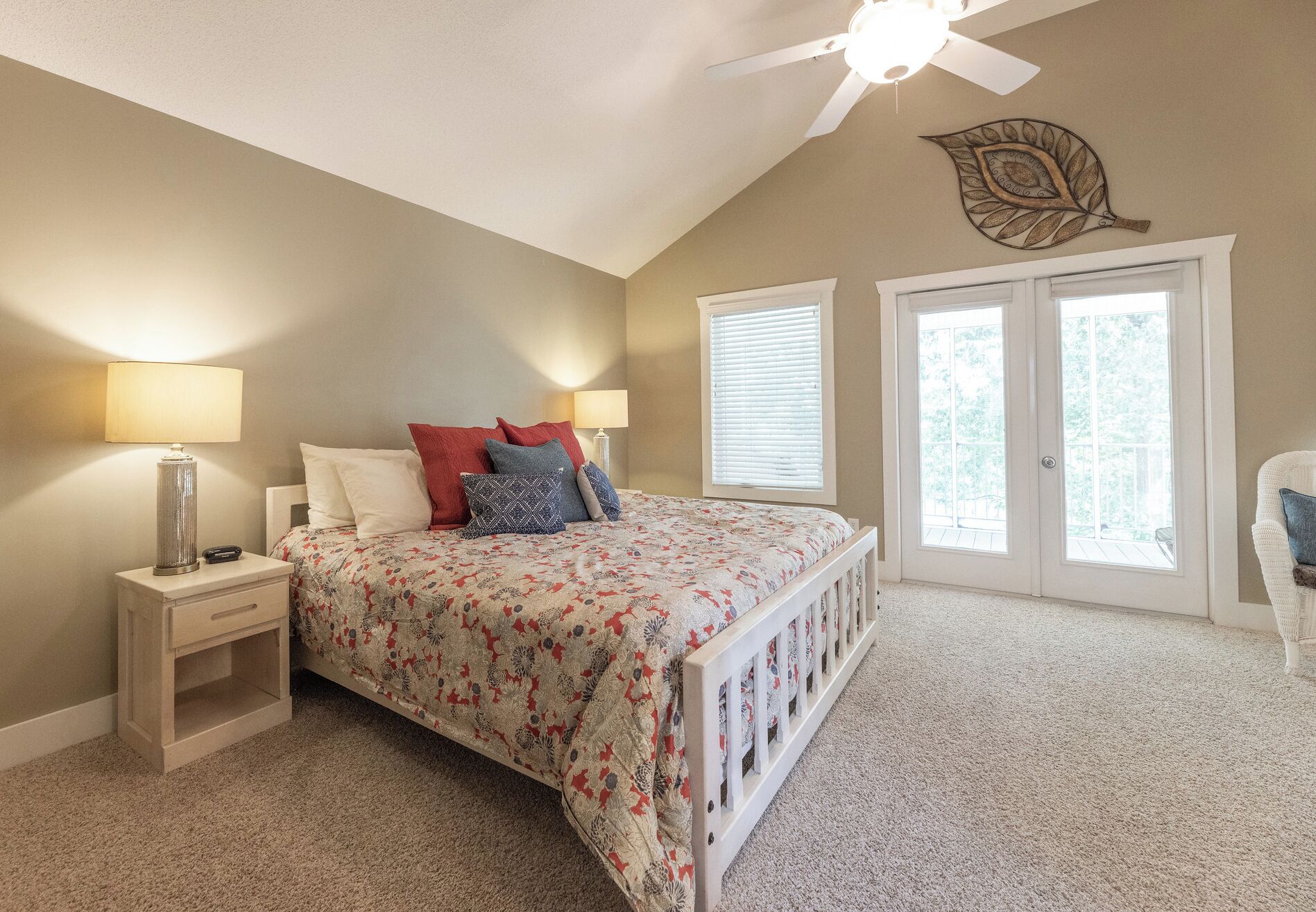 A bedroom with a bed, nightstands, a ceiling fan, and a window with blinds.
