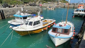 Un port de plaisance où sont amarrés plusieurs bateaux, dont un qui s’appelle « Atlantis II ».