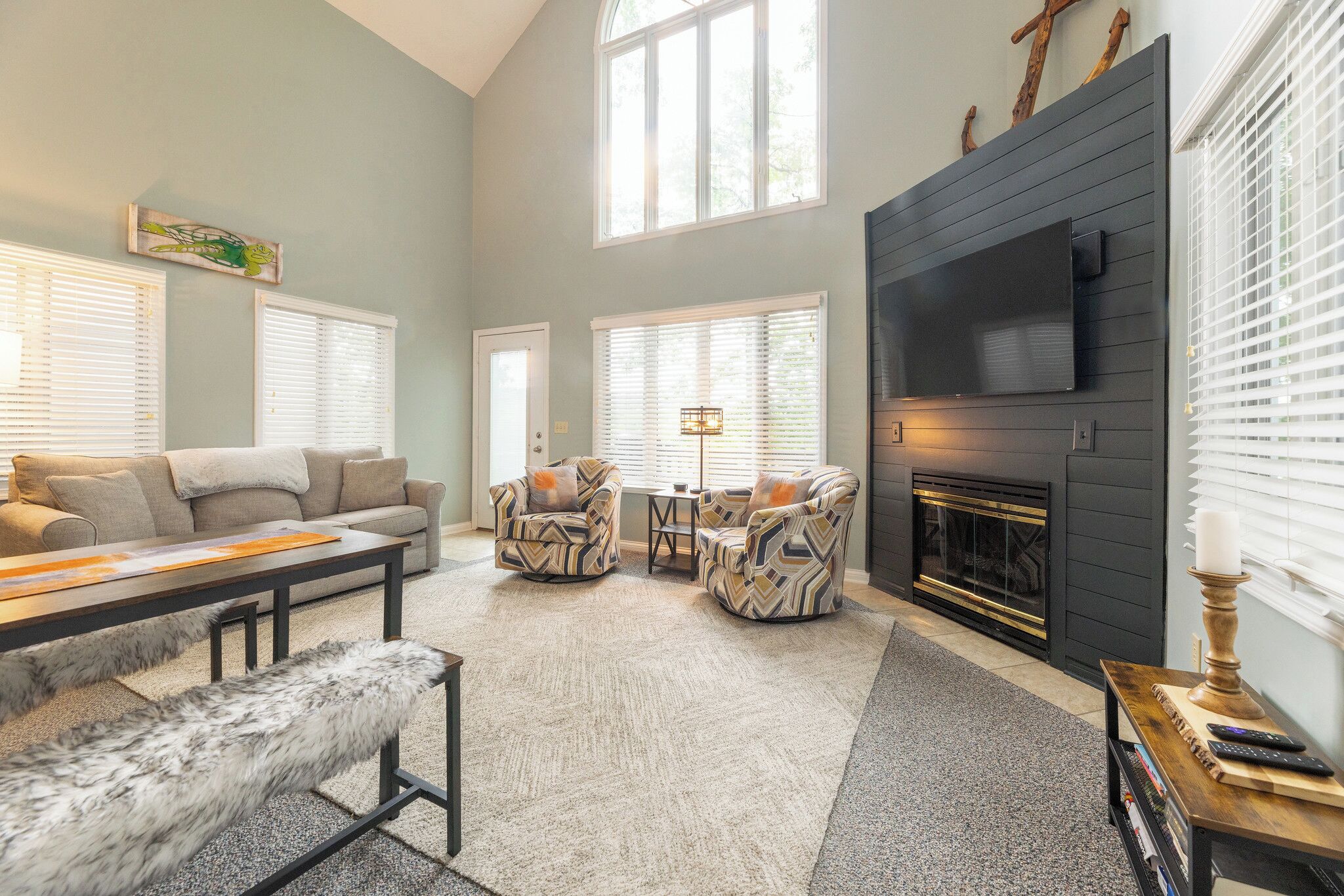 A living room with a fireplace, a sofa, two armchairs, a coffee table, and a bench.