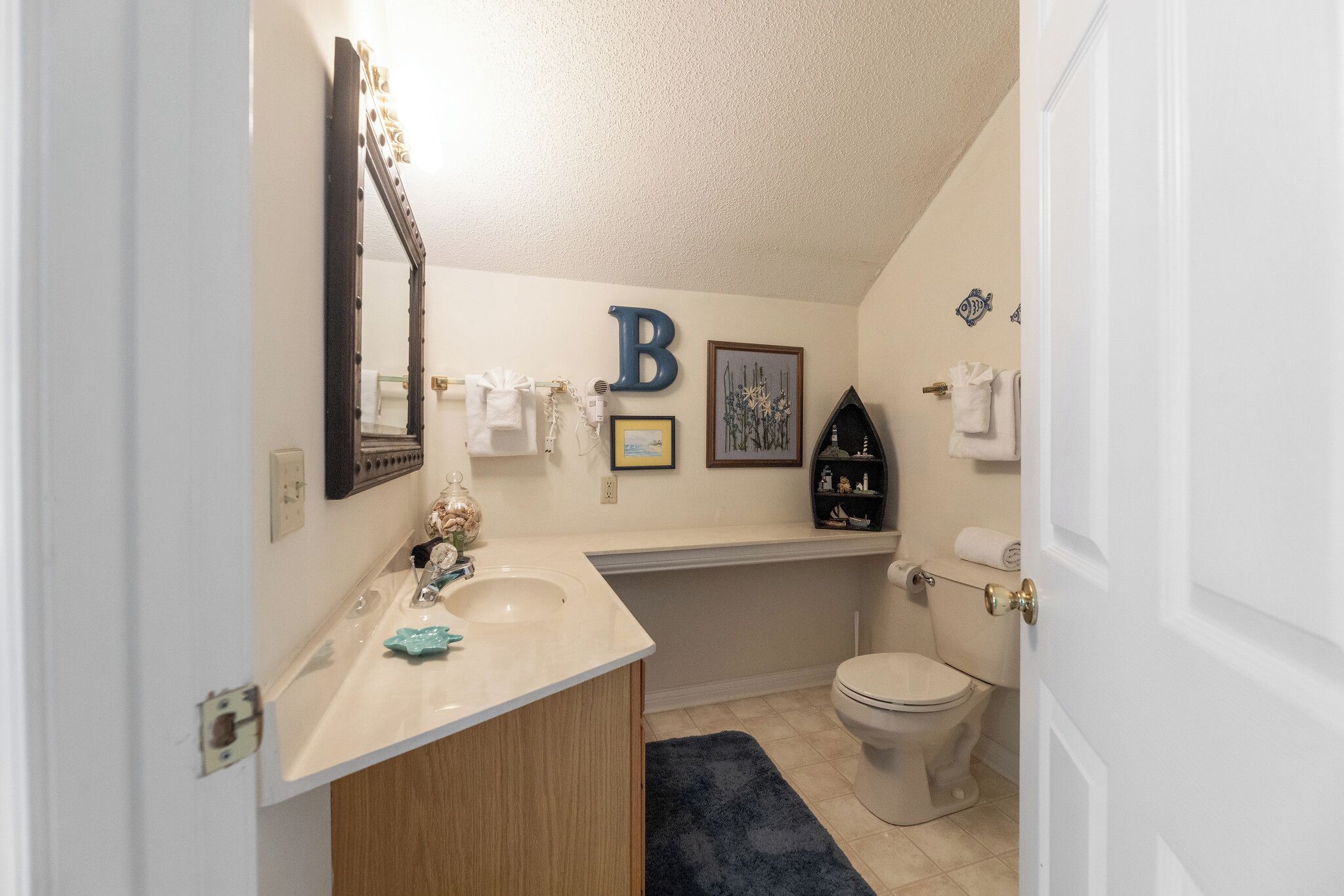 A bathroom with a sink, mirror, toilet, and a bathtub.