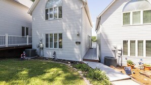 Une maison à deux étages avec un porche à l’avant, une boîte aux lettres et un petit jardin.