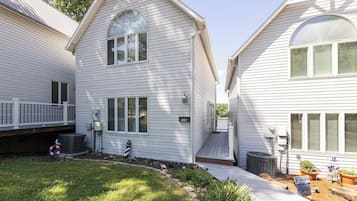 A two-story house with a front porch, a mailbox, and a small garden area.