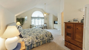 Une chambre à coucher avec un lit, une commode en bois, un bureau et une chaise.