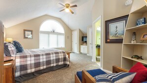 A bedroom with a bed, a desk, a chair, a bookshelf, and a ceiling fan. - Two Bedroom Bayside Condo (Grand Rivers)