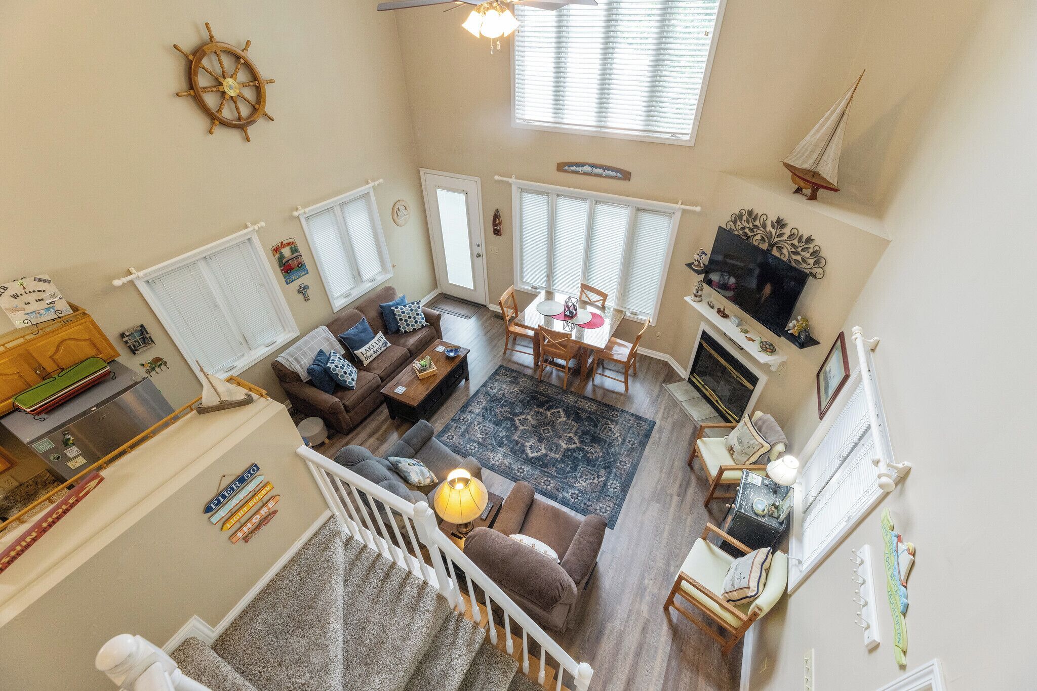 A spacious living room with a staircase, a dining area, and a kitchen.