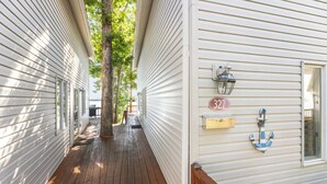 A wooden deck with a mailbox and an anchor decoration on a white house.