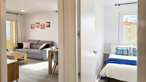 Une chambre à coucher moderne avec un lit, une table de chevet et une vue sur la ville par la fenêtre.