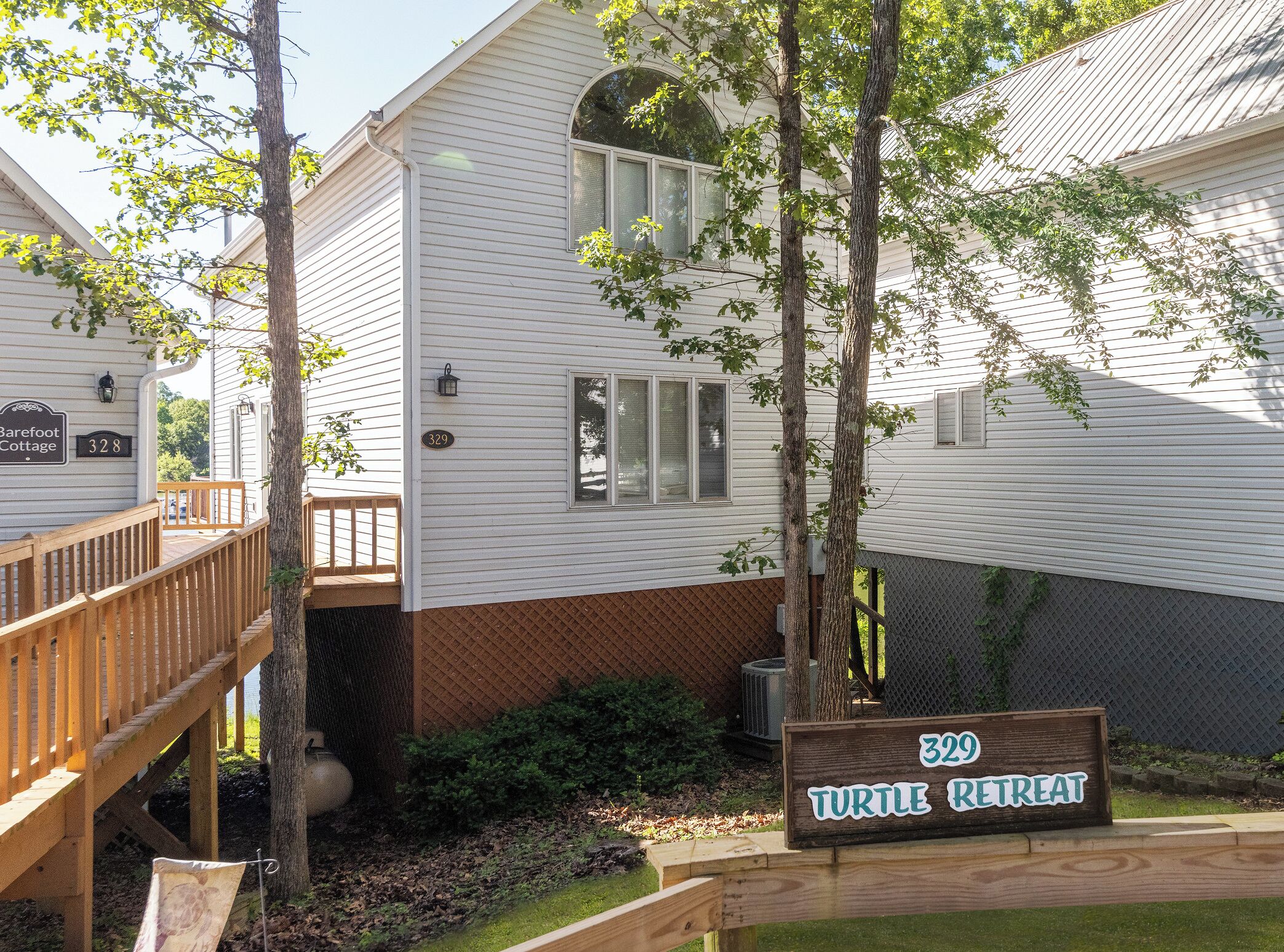 A white building with a wooden deck and a sign reading "329 Turtle Retreat".