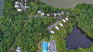 An aerial view of a lakeside property with several buildings, a swimming pool, and a parking area. - Four Bedroom Yacht Condo (Grand Rivers)