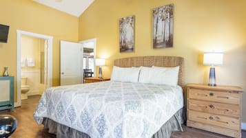 Ein Schlafzimmer mit einem großen Bett, einem hölzernen Nachttisch und zwei an der Wand befestigten Bildern.