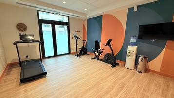 Ein Fitnessstudio mit Laufbändern, Ergometer und Wasserspender.