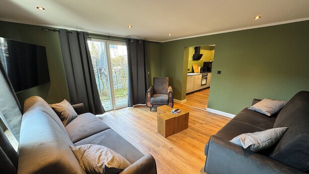 Un salon moderne avec deux canapés, une table basse et un téléviseur.