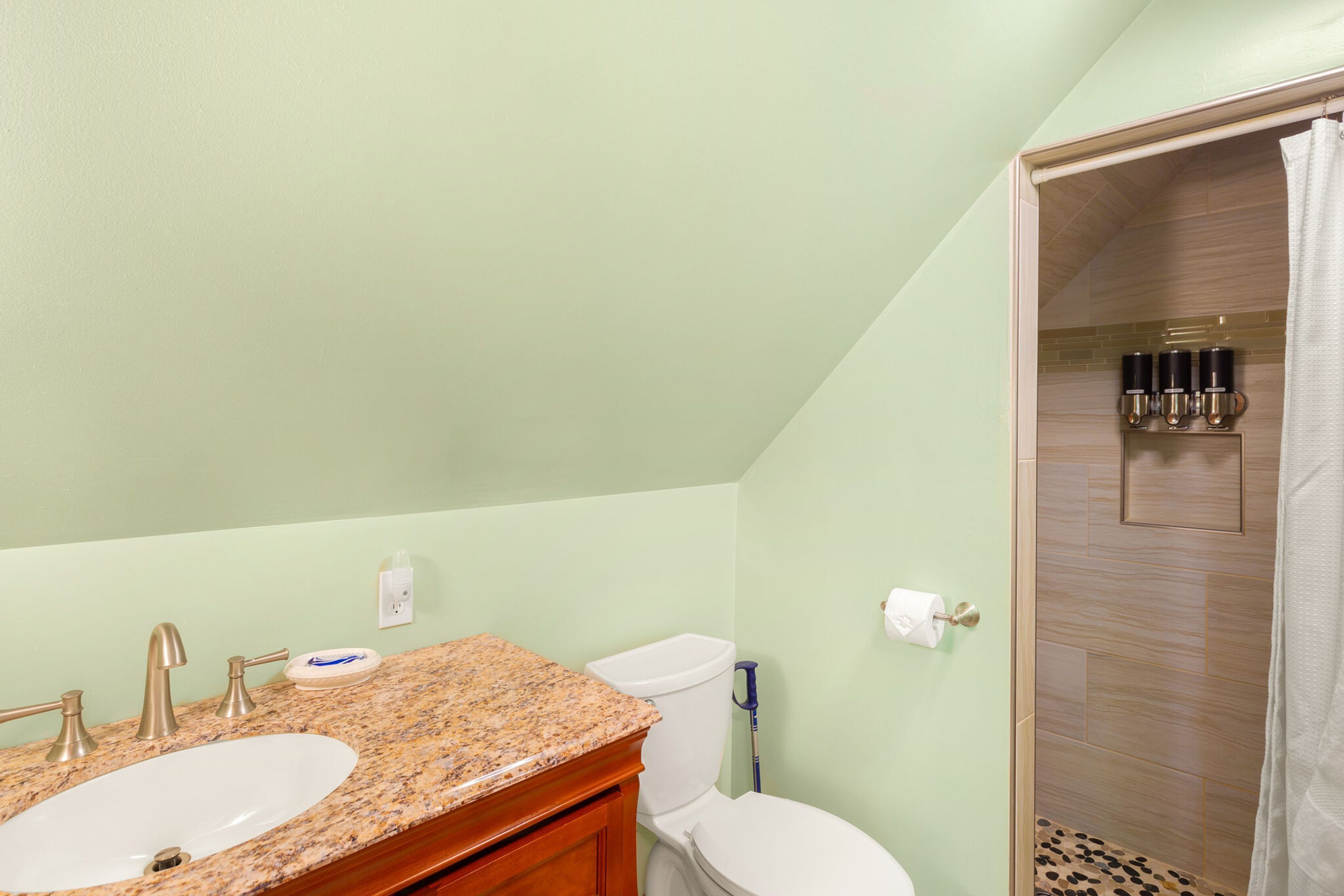 A bathroom with two sinks, a toilet, and a shower area.