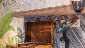 A bar area with a wooden box, a bottle of liquor, and several glasses on a marble countertop. - Stylish Jungle Retreat Kolonaki Center (Athens)