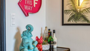 A wall with a red sign that reads "SURF THIS WAY" and a framed picture of a palm tree. - Stylish Jungle Retreat Kolonaki Center (Athens)