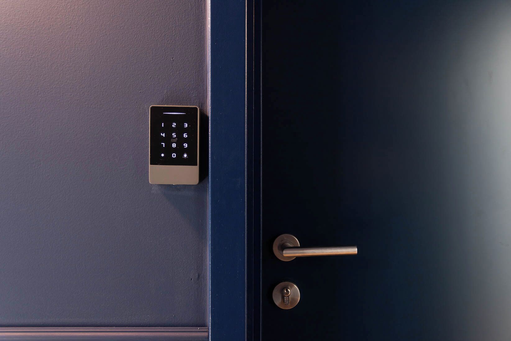 Een blauwe deur met een keypad-slot en een sleutelgat.