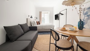 A modern living room with a sofa, dining table, chairs, and a coffee table. - Lapa Diplomatic Suite&Flat by FeelLisboa (Lisbon)
