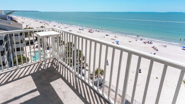 A balcony with a view of a beach and ocean.