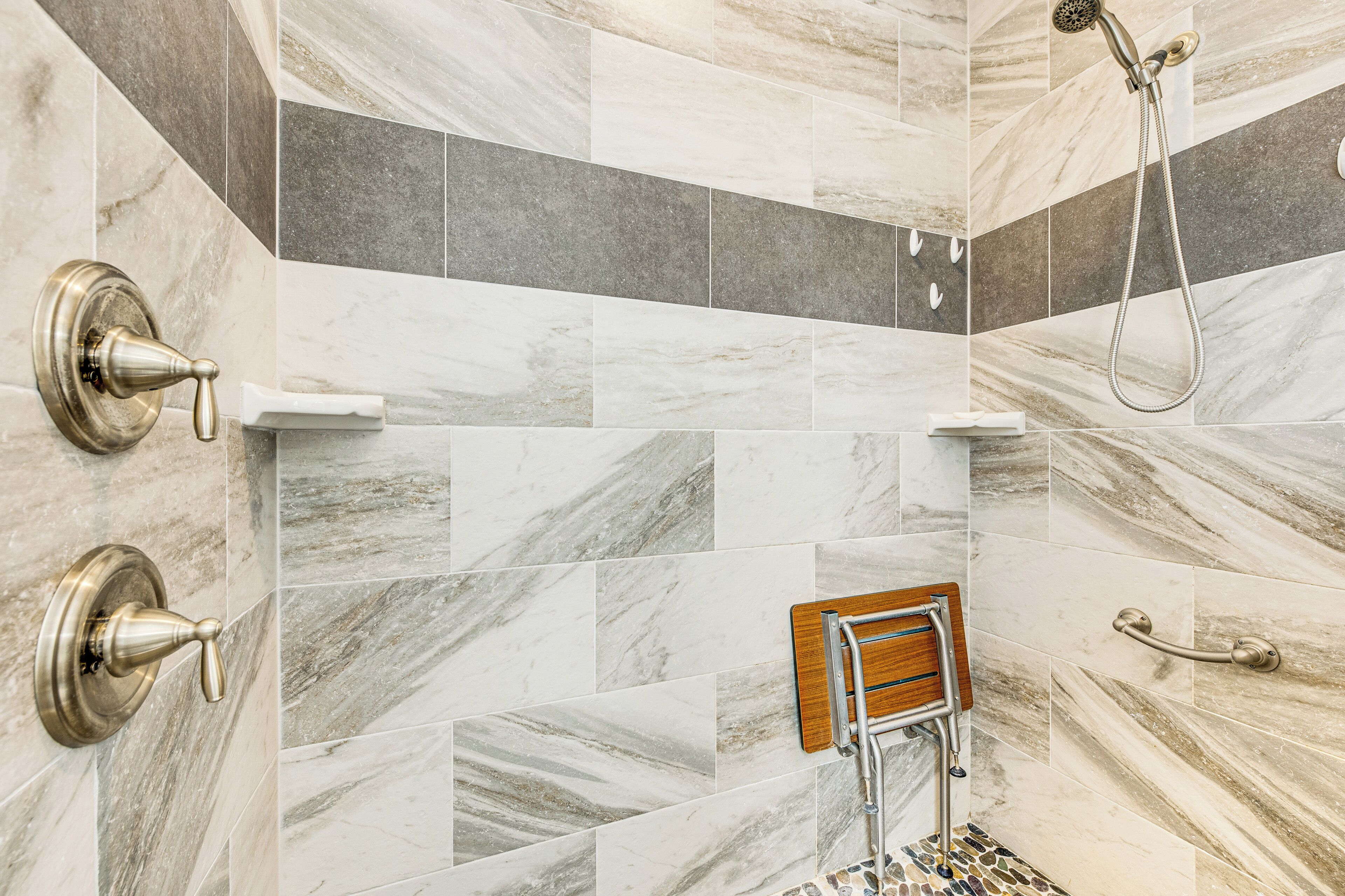 A bathroom with a shower, a toilet, and a grab bar.