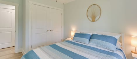 Un dormitorio con una cama grande, un armario blanco y un ventilador de techo.
