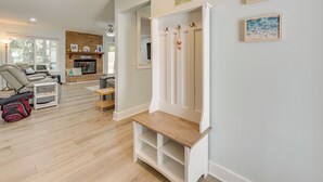 A modern living room with a fireplace, a seating area with a sofa and armchairs, and a wooden bench. - 5 Mi to Dtwn Beaufort: Home w/ Screened-in Patio (Port Royal)