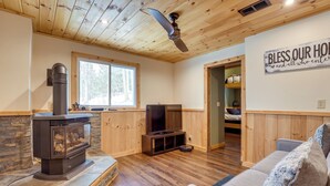 A cozy living room with a fireplace, a television, and a comfortable couch. - The Toasted Marshmallow Ski & Lake Game Barn (Canandaigua)